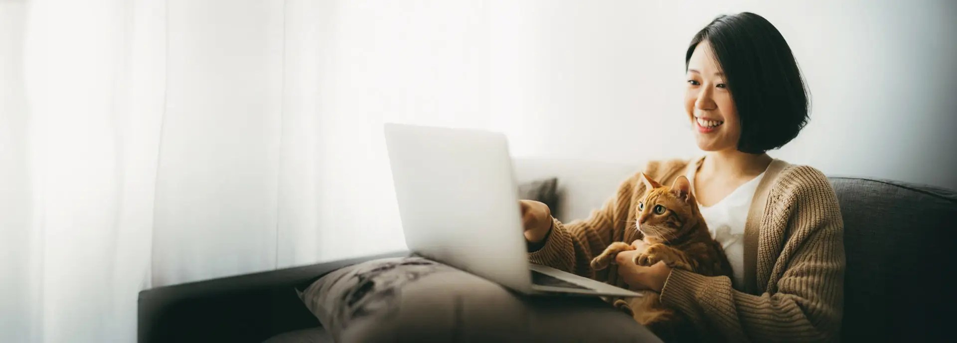 Woman at laptop with small cat